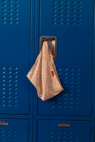 A pair of Kt by Knix floral period underwear rests gently on the handle of a school locker