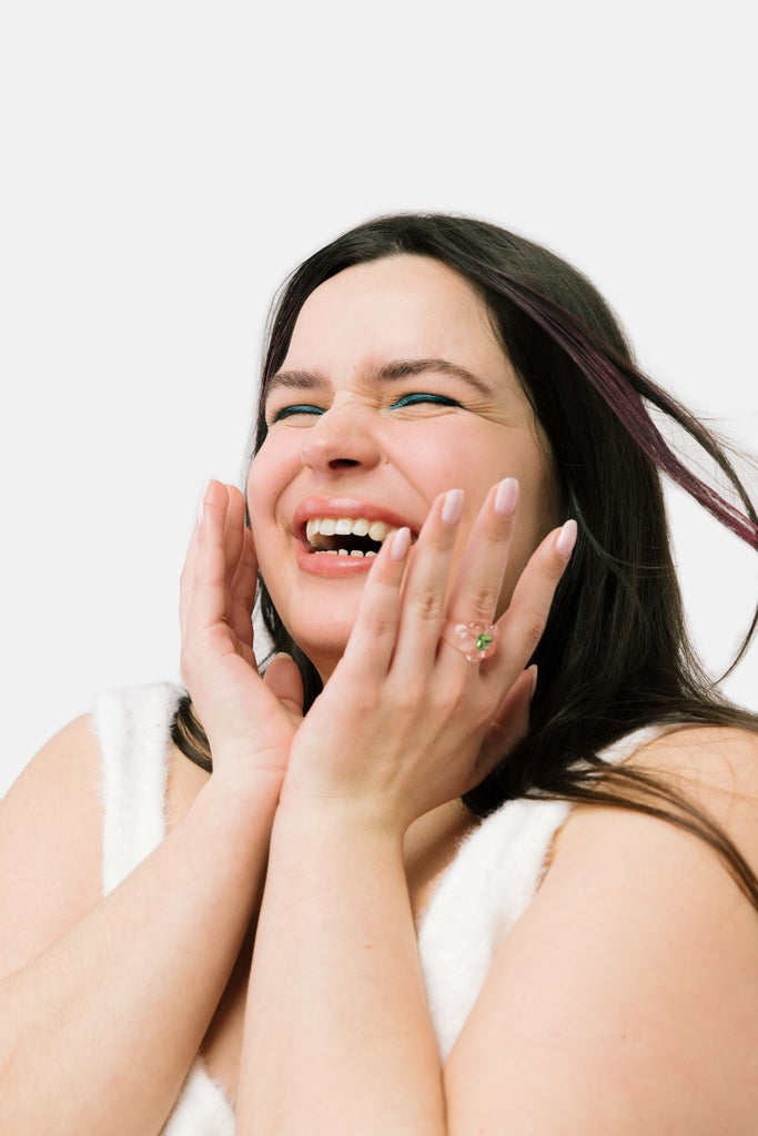 teen holding face in hands and smiling