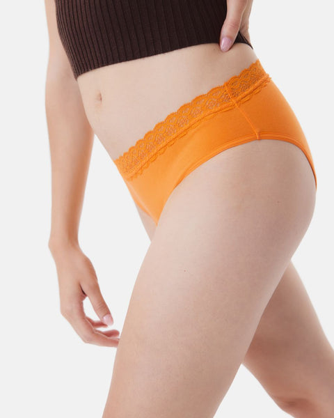 Close-up of a white woman's torso wearing orange Kt by Knix cotton leakproof lace underwear